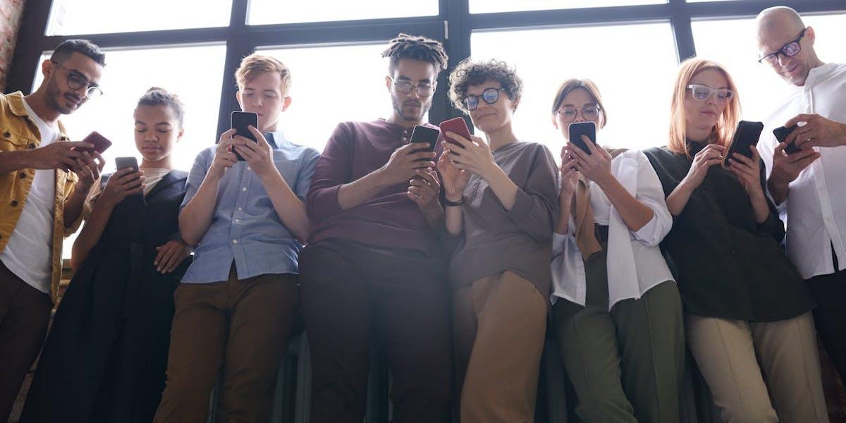 Ungdomar stirrar ned i sina mobiltelefoner