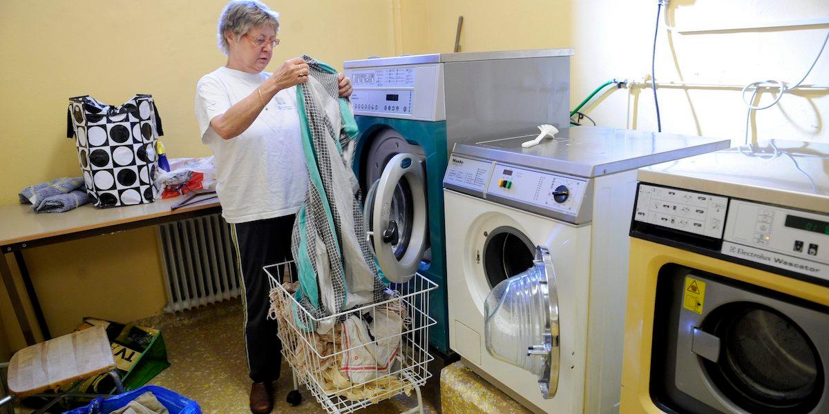 En kvinna tar ur tvätt ur en tvättmaskin. Den gemensamma tvättstugan i flerbostadshus kan försvinna, det menar en etnolog