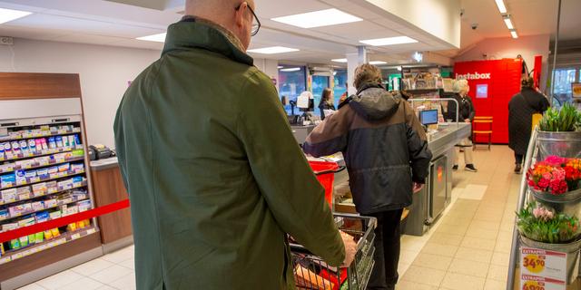 En man handlar mat och står i kö på ICA i Kivik. Det blev lite billigare att handla mat i augusti då priserna på livsmedel sjönk något jämfört med juli.