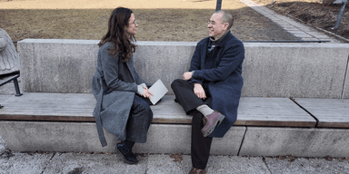 En kvinna och en man på en bänk pratar om förluster.