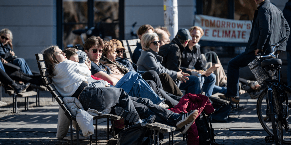 Vår och människor på bänkar i solen.