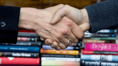 Två personer som testar greppstyrkan med ett handslag.