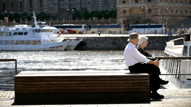 Två äldre personer på en bänk som gått i pension.