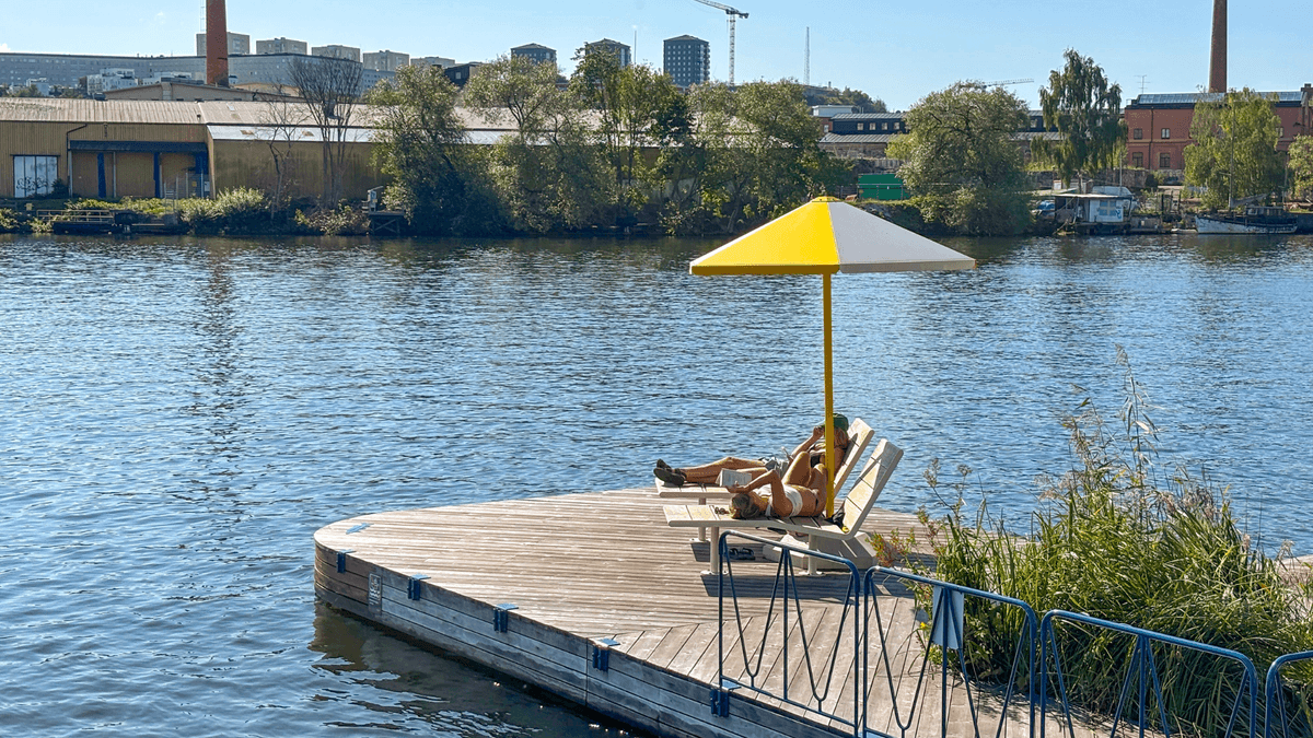 Två personer på resa på en brygga i solen.
