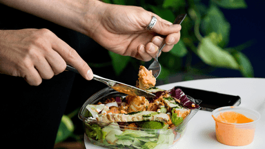 En person som äter en sallad med mycket fibrer.