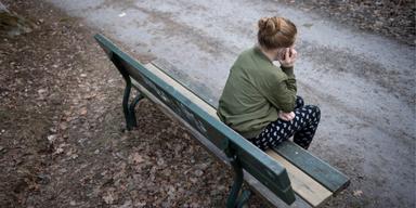 Kvinna på bänk med mobiltelefon